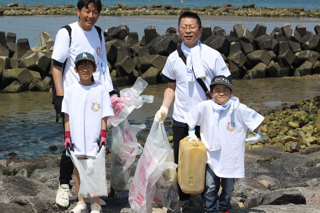 流木の間からプラスチックゴミを回収する様子