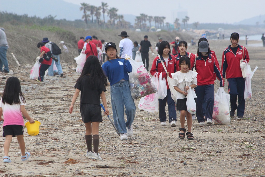 参加者たちが協力して大型ゴミを運ぶ作業風景