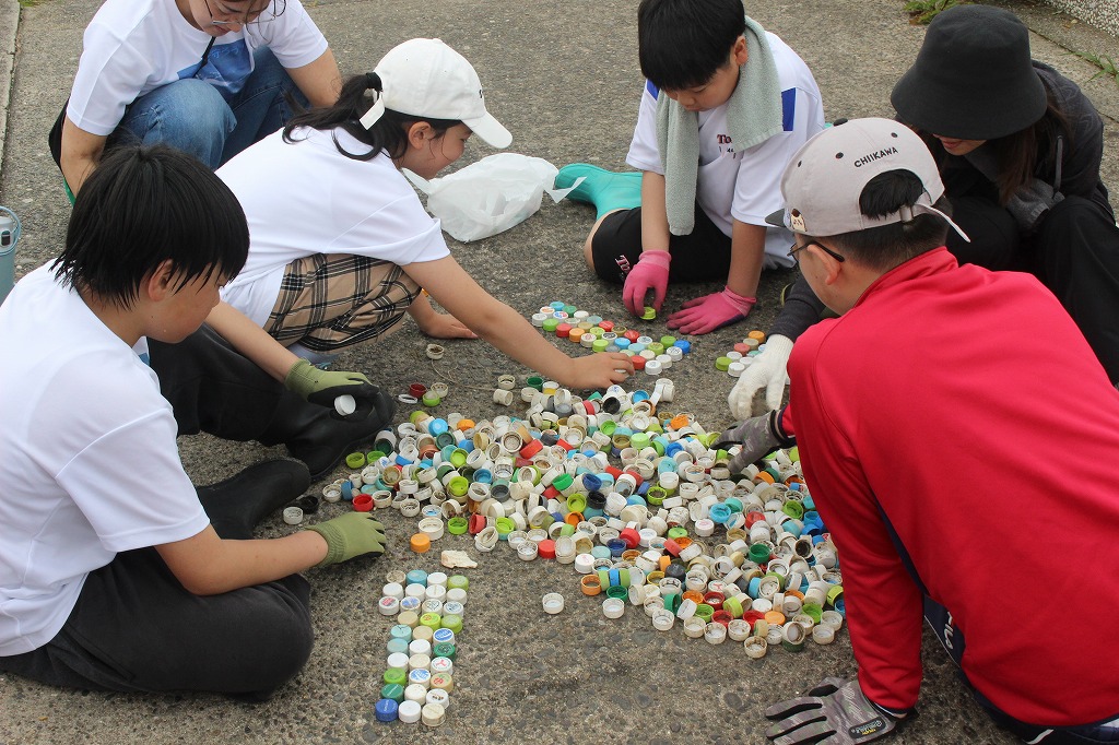 きれいになった西の浜で満足そうな表情を見せる参加者たち