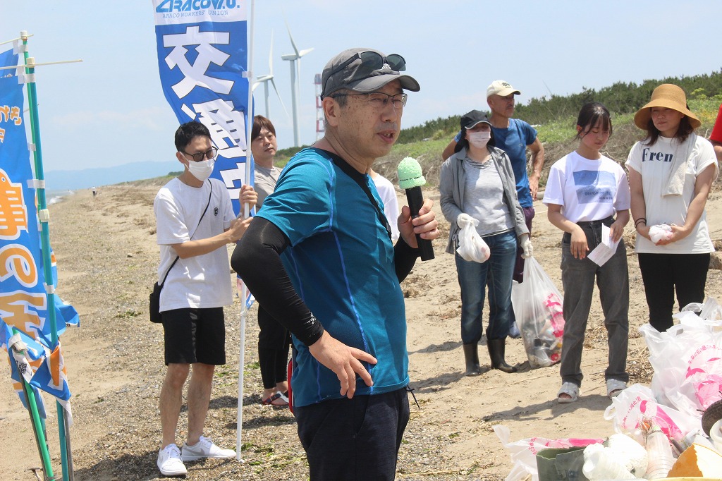 ヒラメの稚魚を海に放流する瞬間を見守る参加者たち