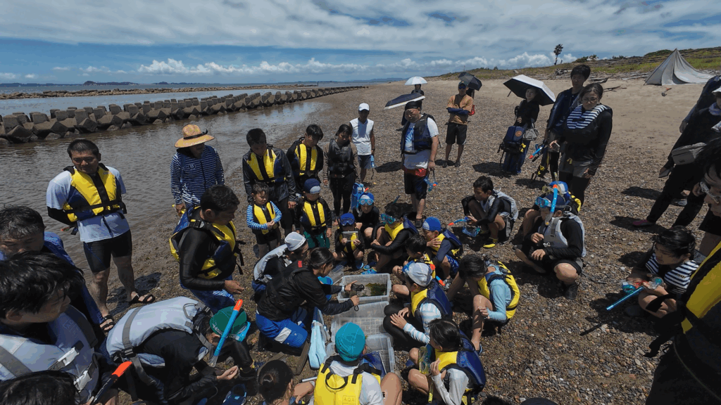 水中で魚を発見し興奮する子どもたちのスノーケリング体験